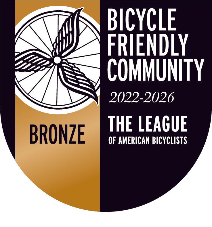 Bronze Bicycle Friendly Community award logo, with a bike wheel, wings, and text.