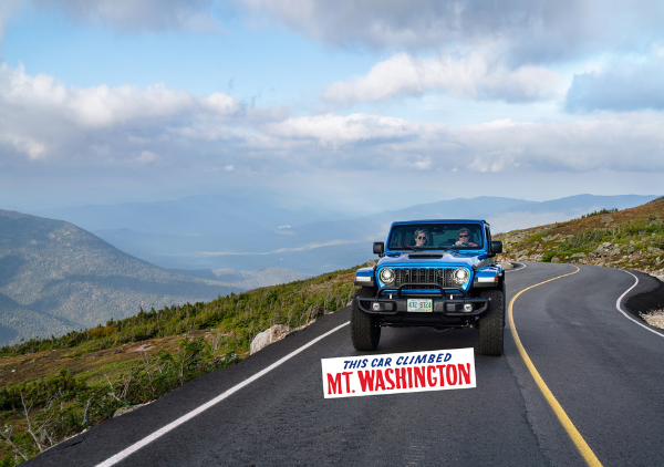 car driving on road with mountains in the background