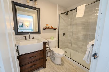 Modern bathroom with vanity, toilet, and glass walk-in shower.