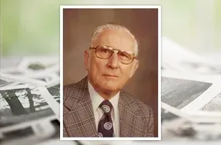 Portrait of an elderly man in glasses and a suit, framed over a background of faded photographs