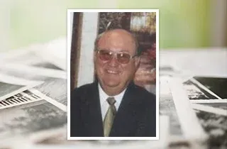 Portrait of a smiling man in a suit and tie, framed over a blurred newspaper background