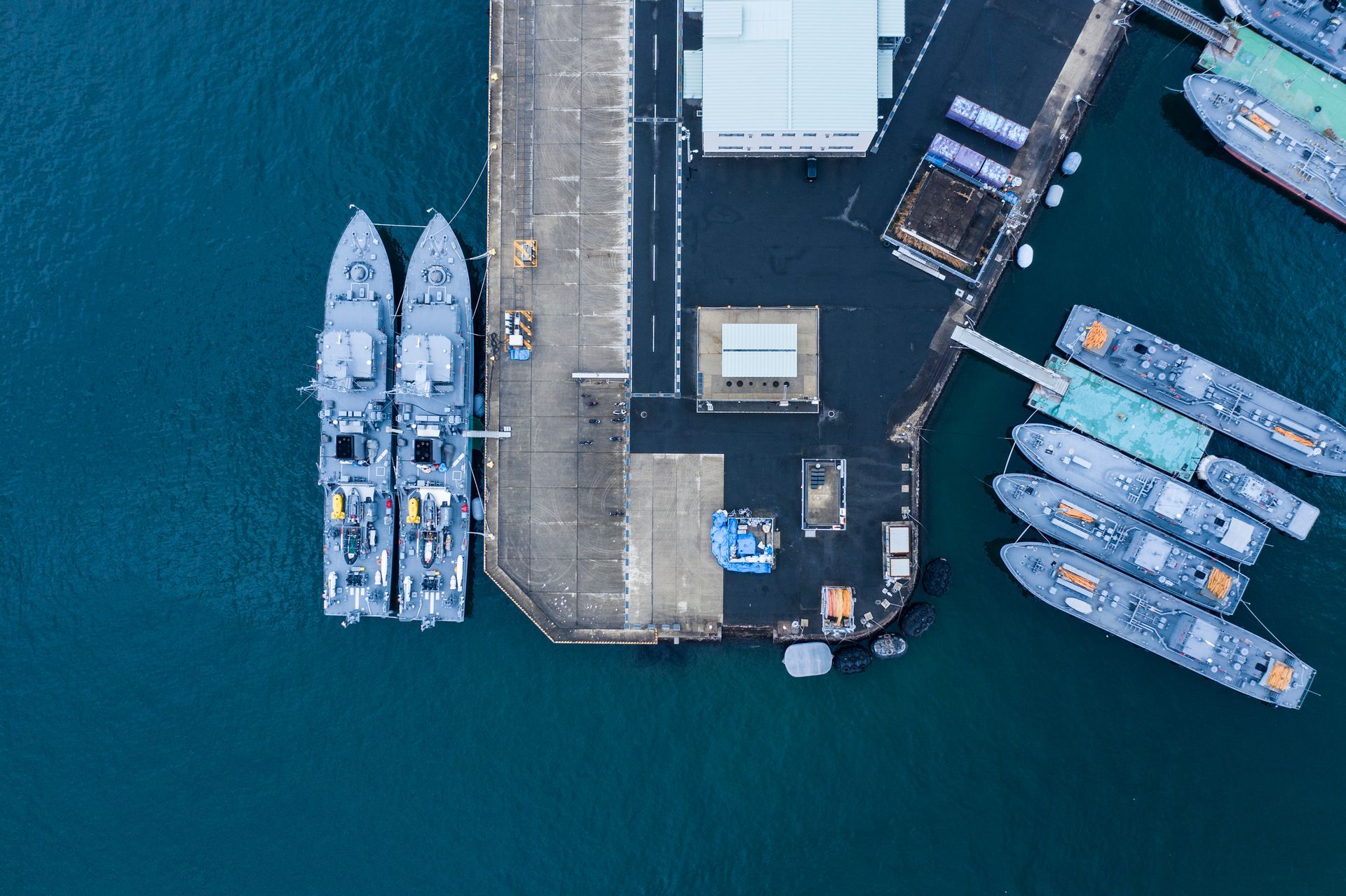 A group of boats are docked at a dock in the water.