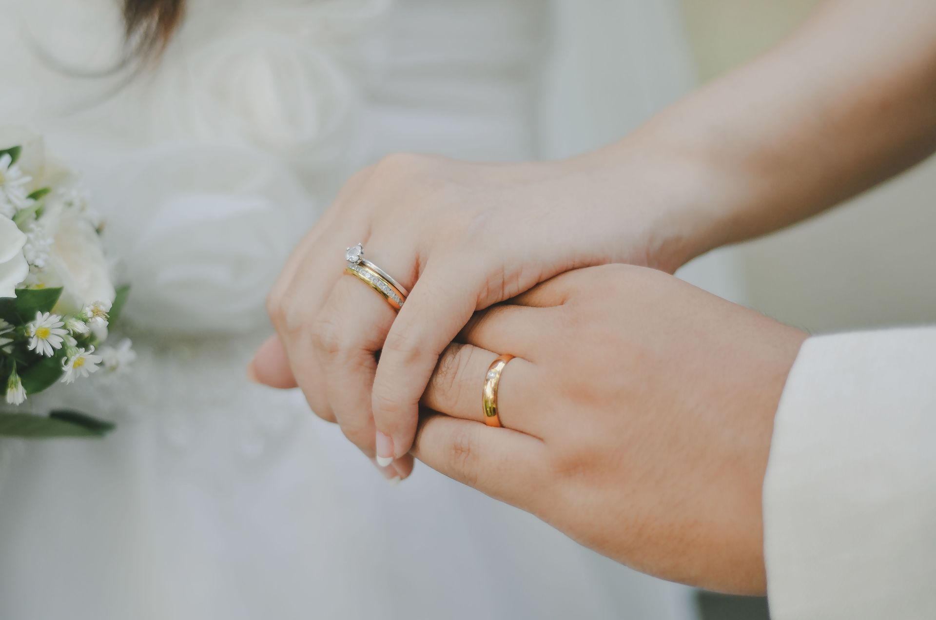 A bride and groom are walking down a path in the woods.