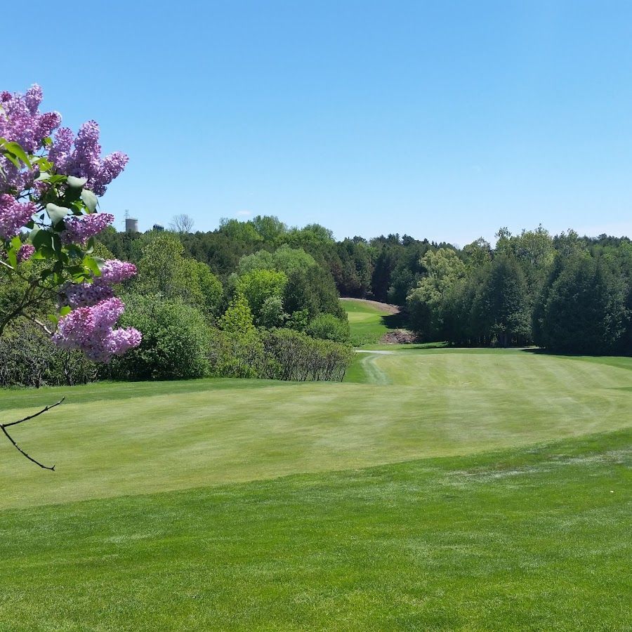 Wide shot of Kedron Dells Golf Club with a golfer and a parked cart on a path.