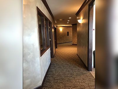 a long hallway with a carpeted floor and a window.