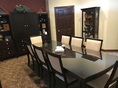 a dining room with a long glass table and chairs.