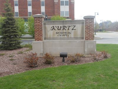 a sign for Kurtz Memorial Chapel is in front of a brick building.