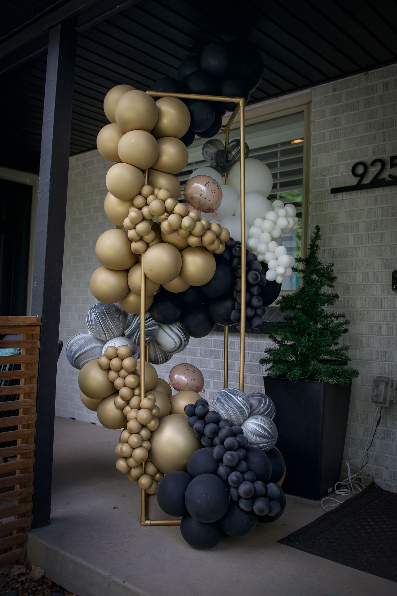 A bunch of balloons are sitting on a porch in front of a building.
