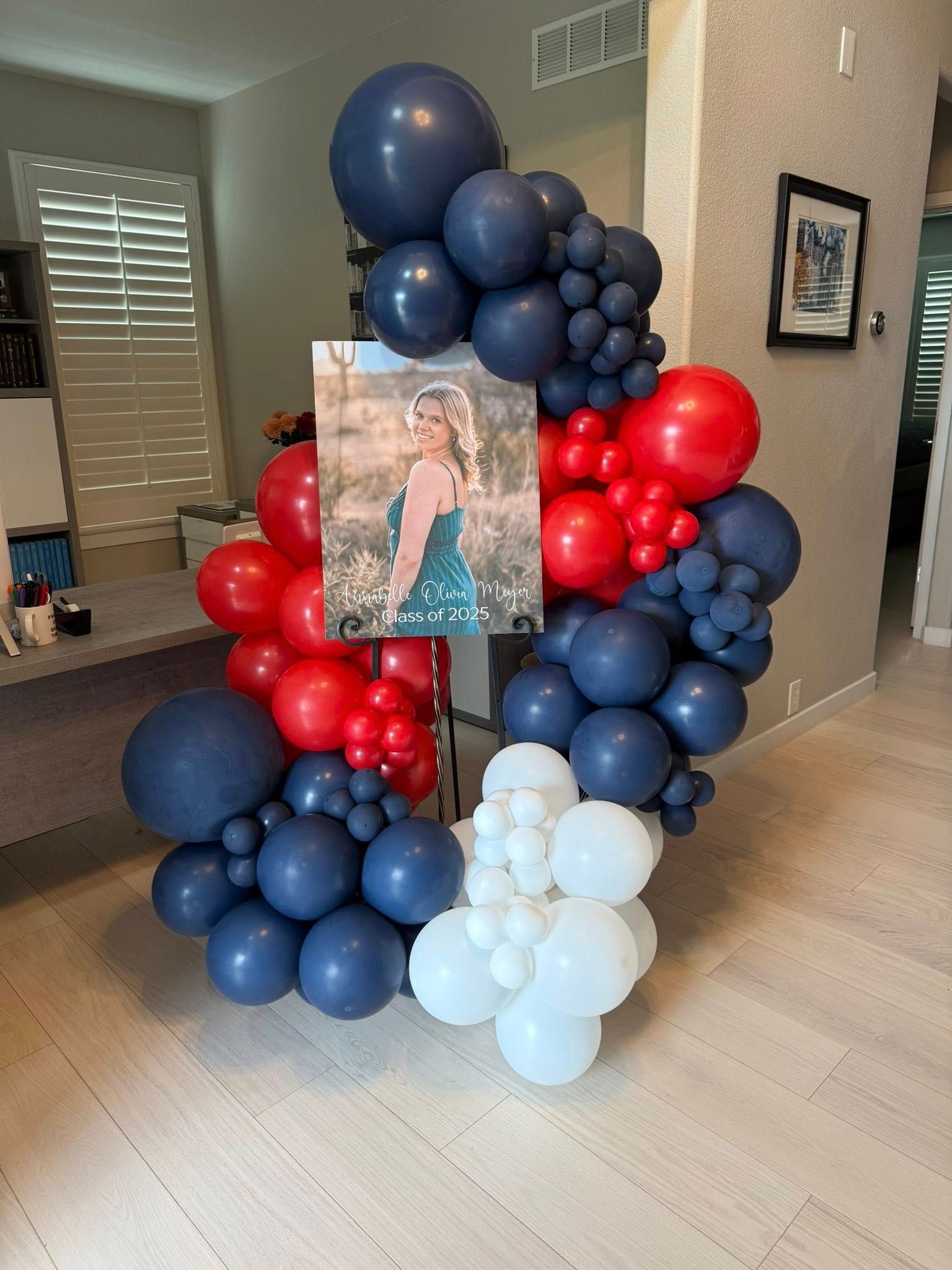 A bunch of red , white and blue balloons are sitting on the floor in a room.