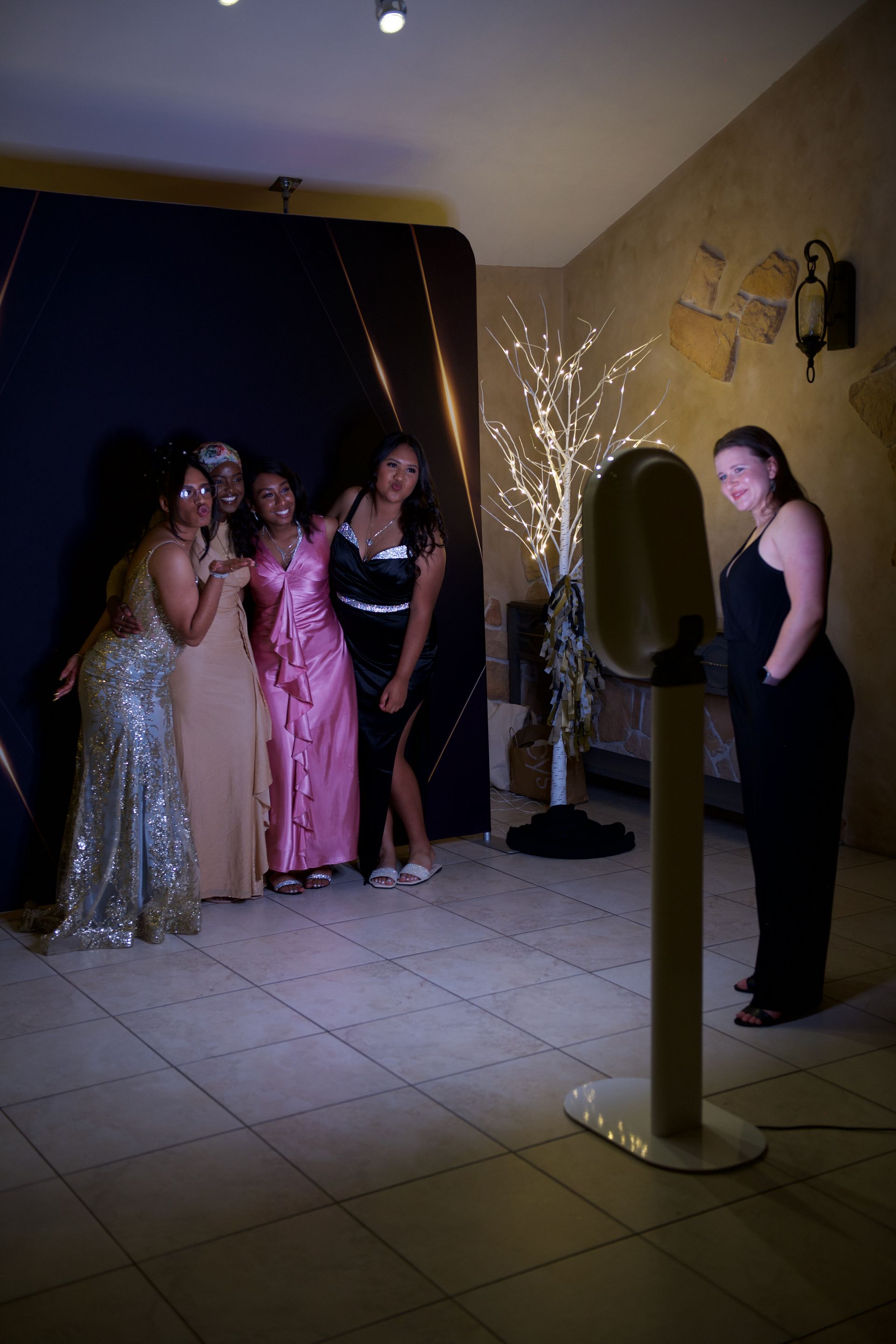 A group of women are posing for a picture in front of a photo booth.
