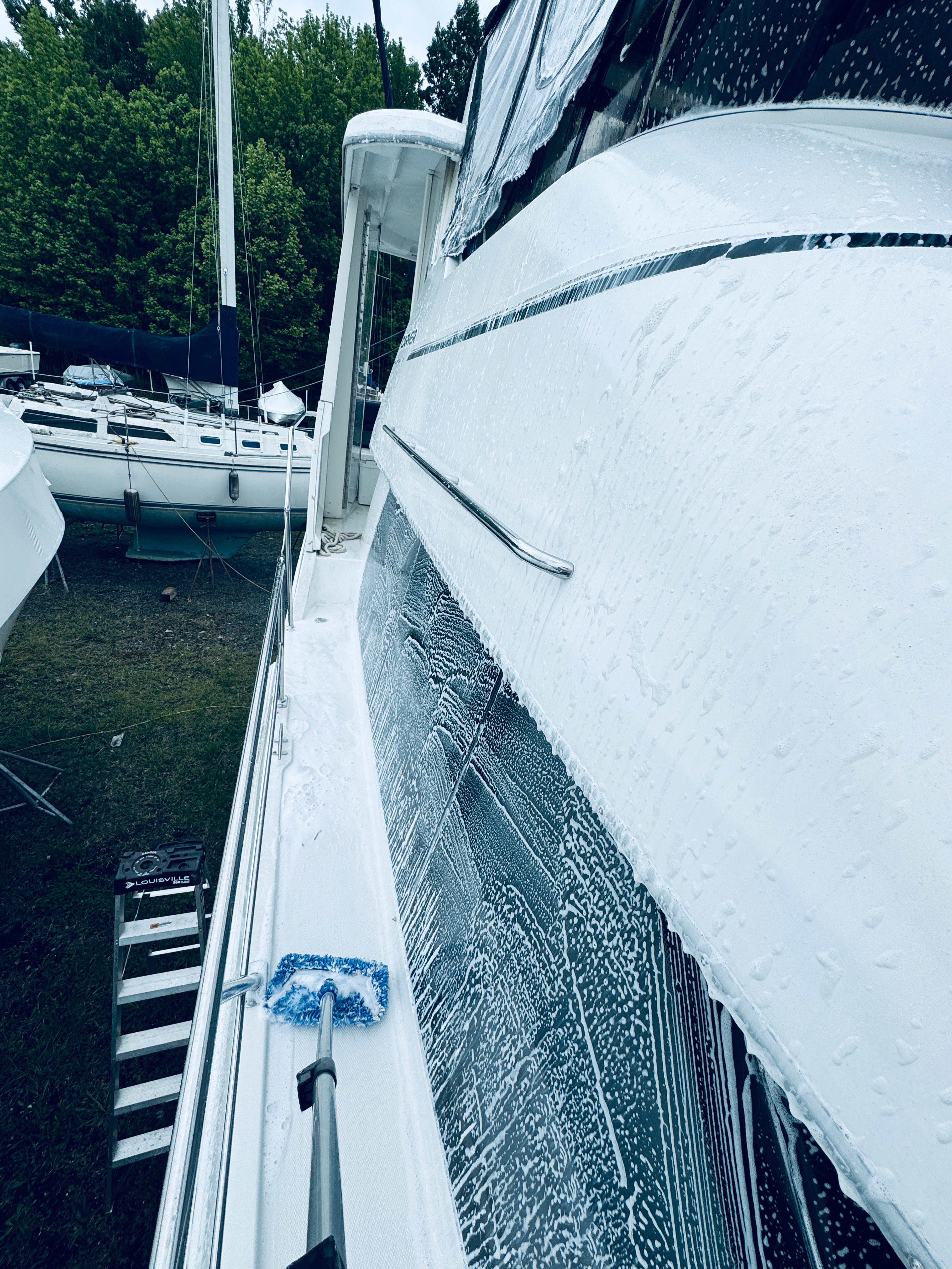 A man is spraying something on the floor of a boat