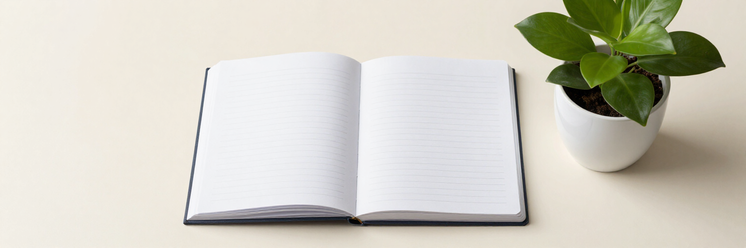 Un cuaderno abierto junto a una pequeña planta en maceta sobre un escritorio limpio.