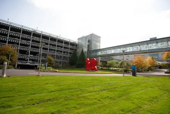 Exterior view of a multi-story parking garage and building connected by a glass enclosed walkway.