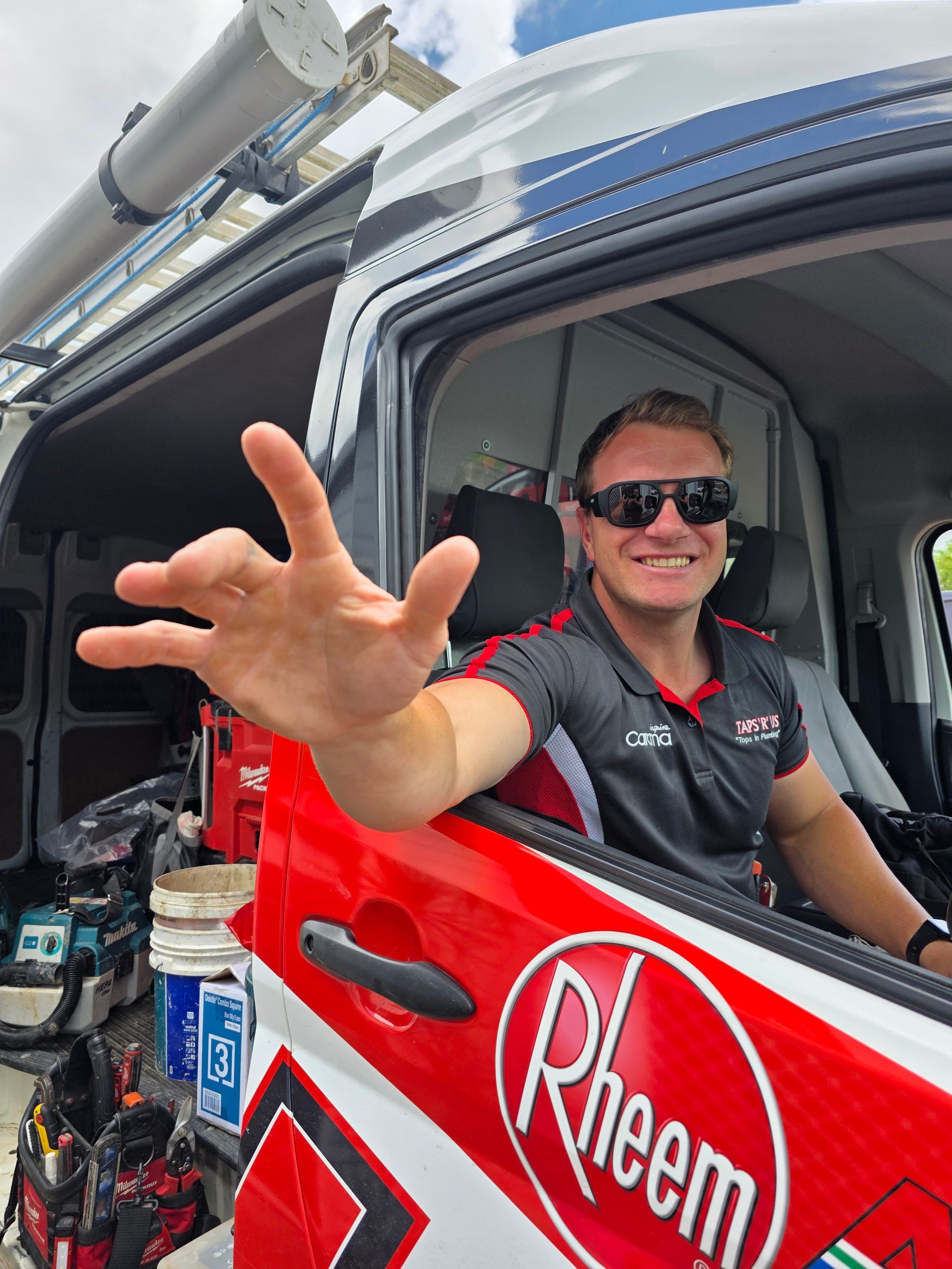 Driver Smiling and Reaching from A Red Rheem Truck Window — Taps 'R' Us in Kunda Park, QLD