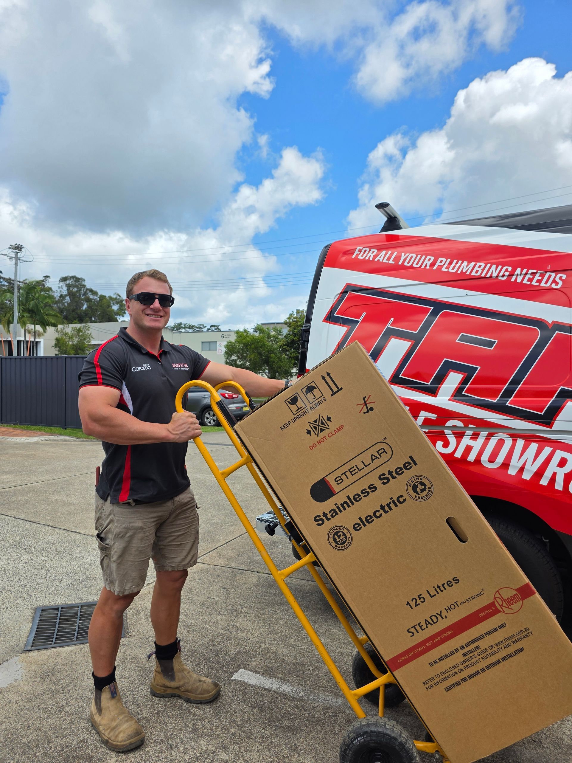 Man in Sunglasses Loading a Large Cardboard Box onto A Yellow Hand Truck Outdoors — Taps 'R' Us in Kunda Park, QLD
