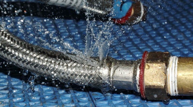 Water spraying from a damaged braided metal hose connected to a brass fitting — Taps 'R' Us in Mountain Creek, QLD