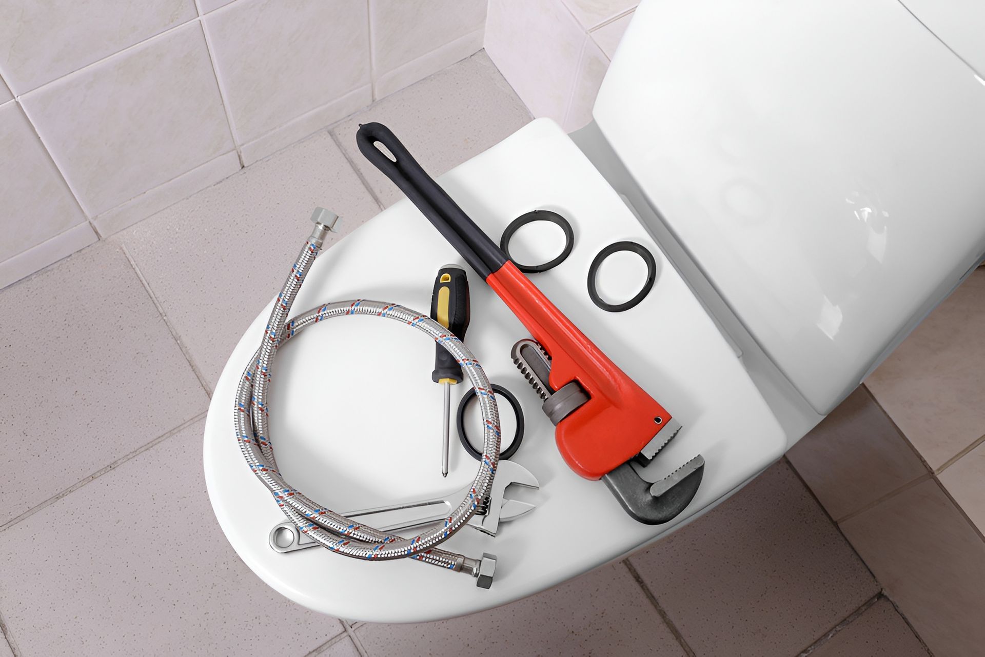 Plumbing Tools on a White Toilet Seat — Taps 'R' Us in Kunda Park, QLD