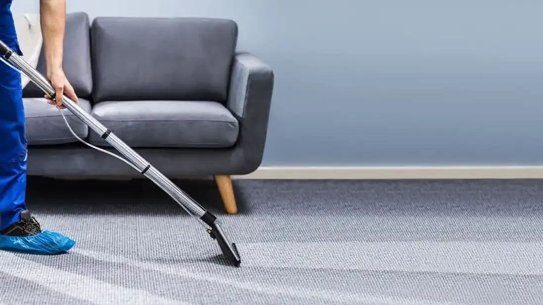 Professional carpet cleaner, cleaning a carpet in a lounge