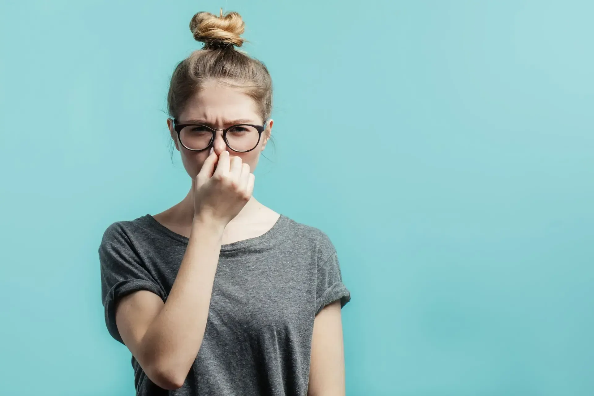 Woman holding her nose due to a bad smell