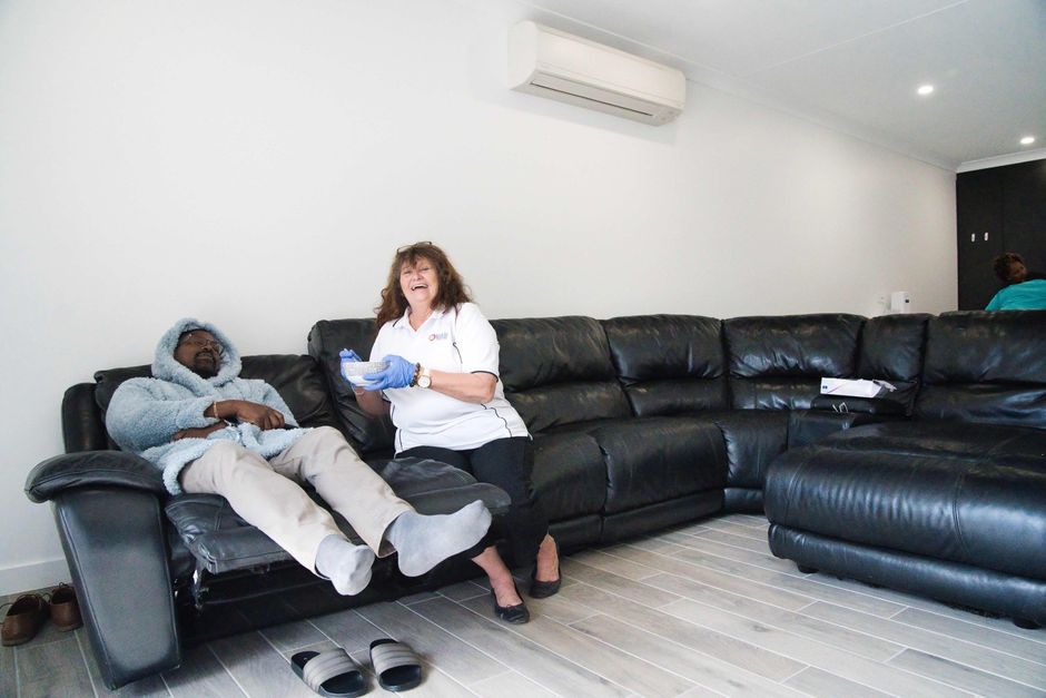 A man and a woman are sitting on a couch in a living room.
