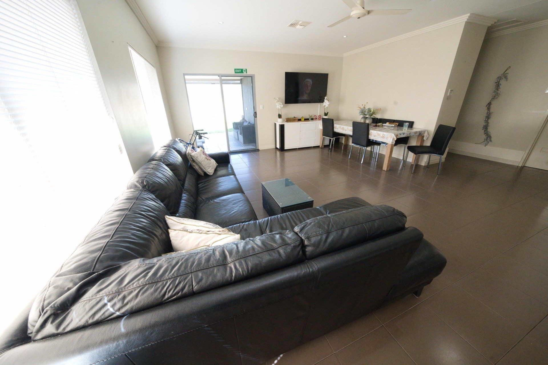 A living room with a couch , table , chairs and television.