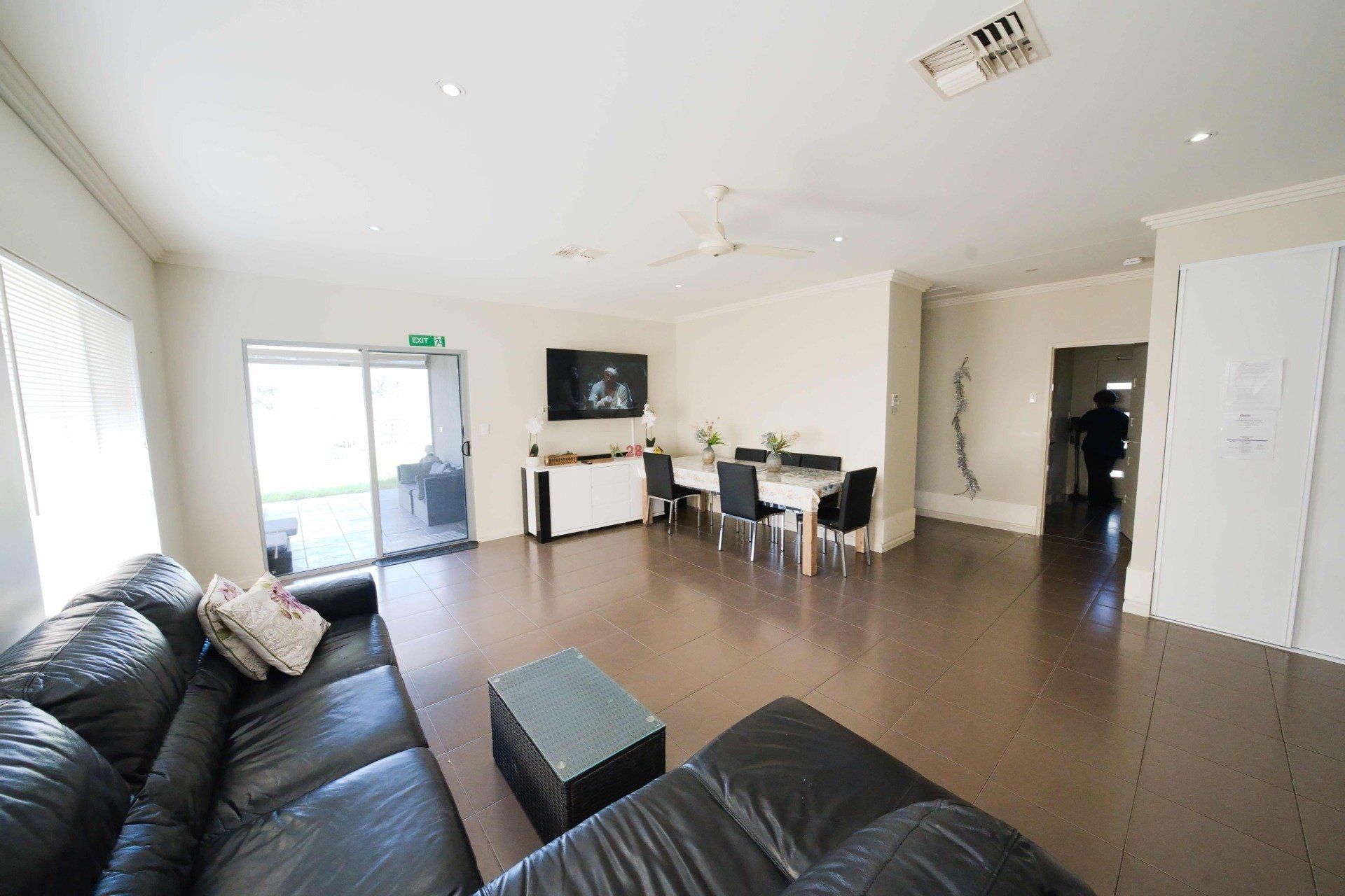 A living room with a couch , table , chairs and television.
