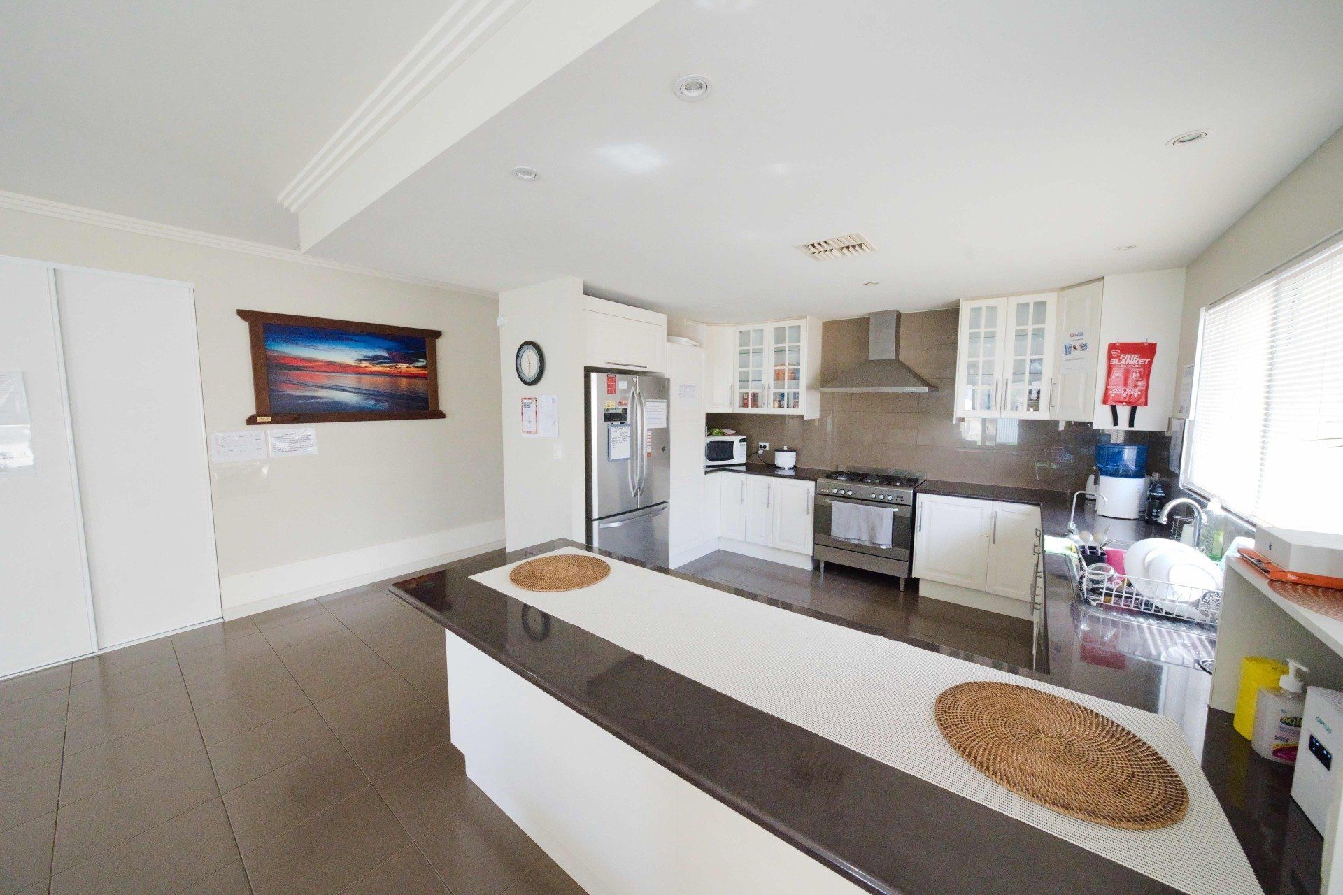 A kitchen with a large island and a painting on the wall