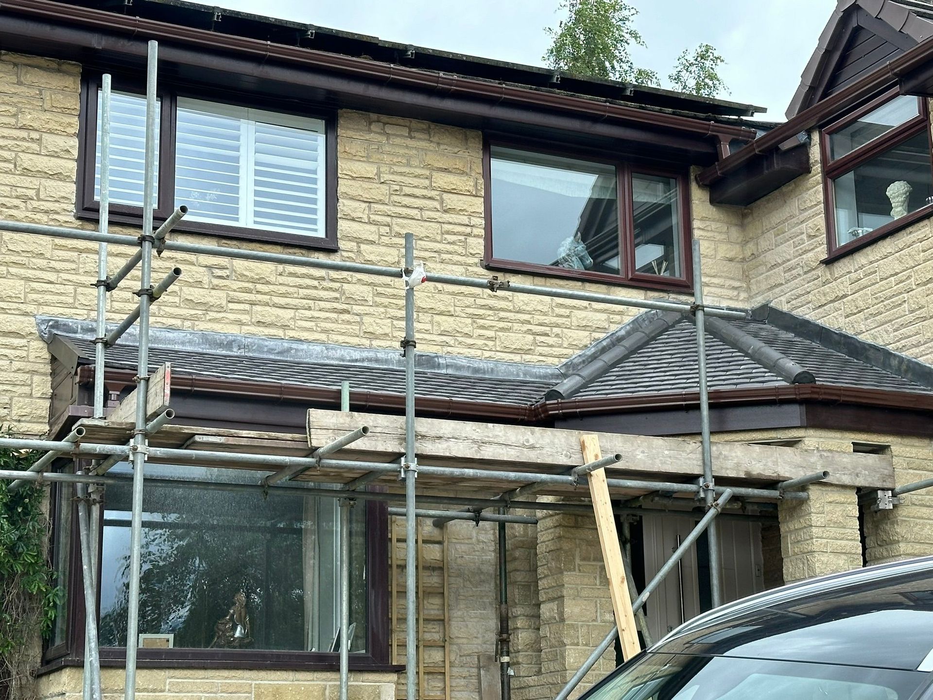 Stone house with windows and scaffolding during exterior renovation