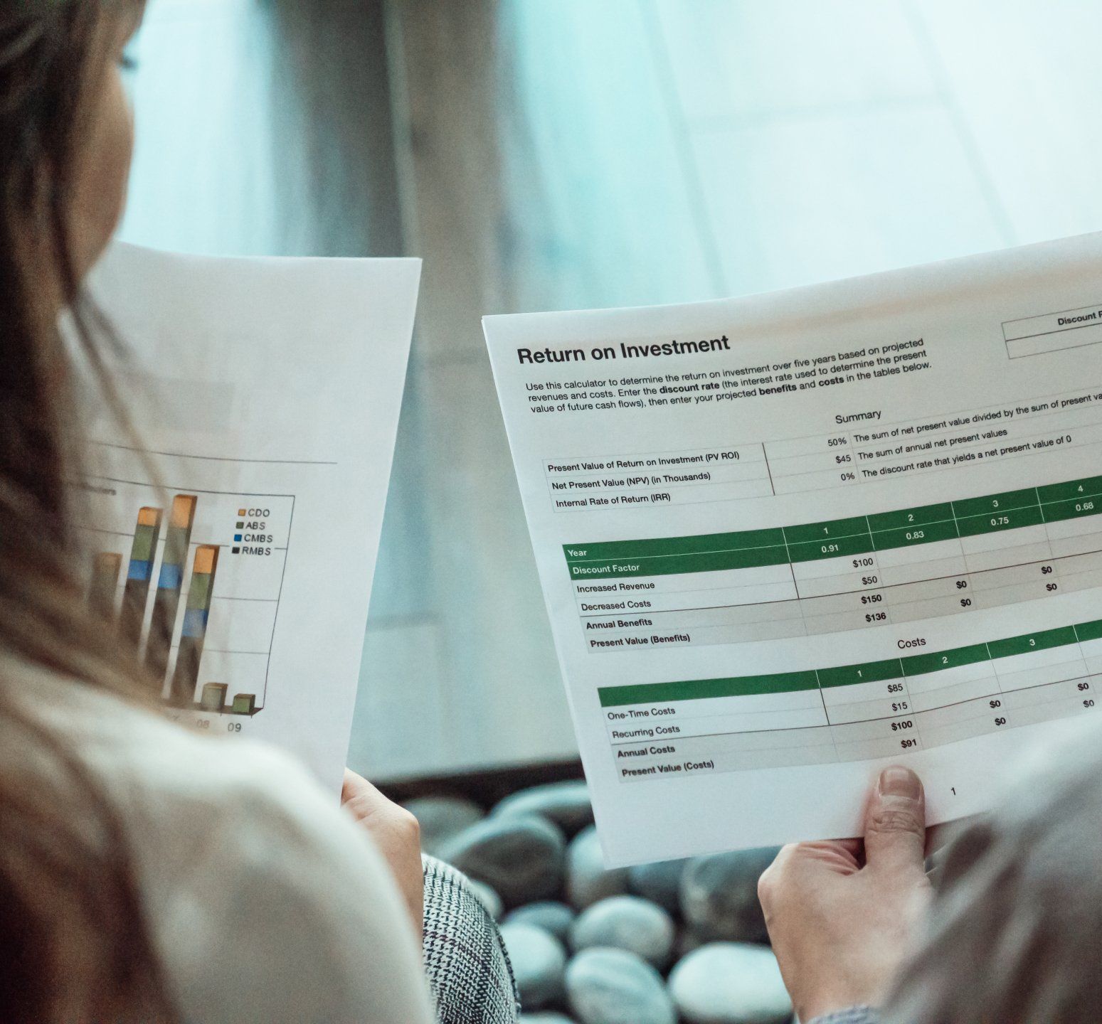A woman is holding a piece of paper with a graph on it.