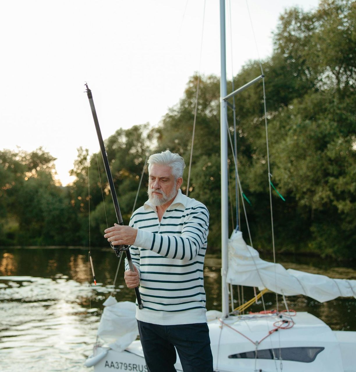 A man is standing on a boat holding a fishing rod