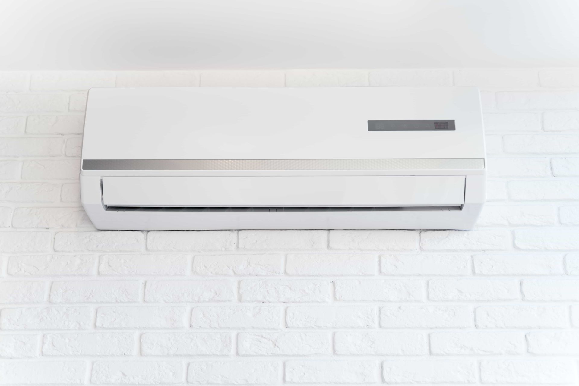 A row of air conditioners are sitting on the side of a building.