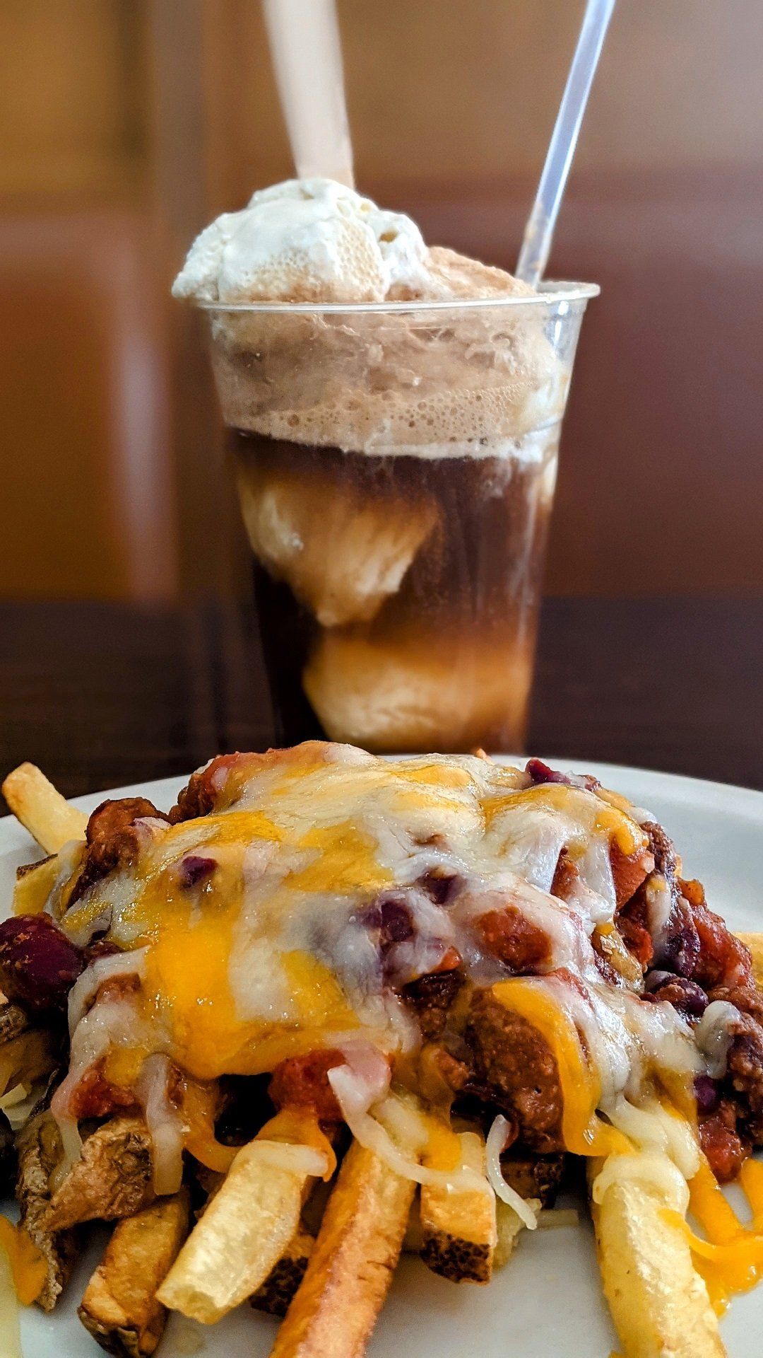 A close up of a plate of food with a drink in the background.