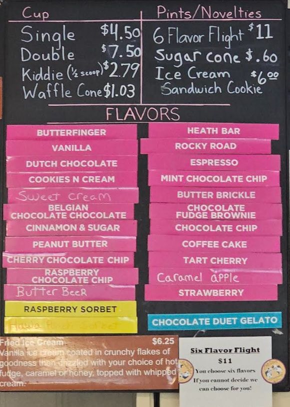Three scoops of ice cream are stacked on top of each other in a waffle cone.