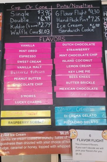 Three scoops of ice cream are stacked on top of each other in a waffle cone.