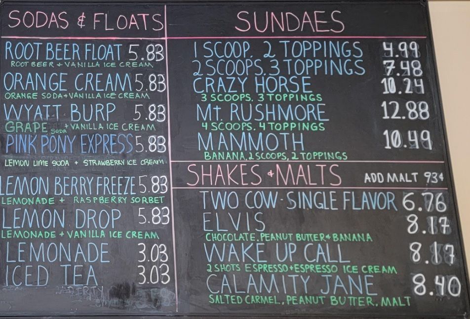 A chalkboard menu for sodas and floats and sundaes