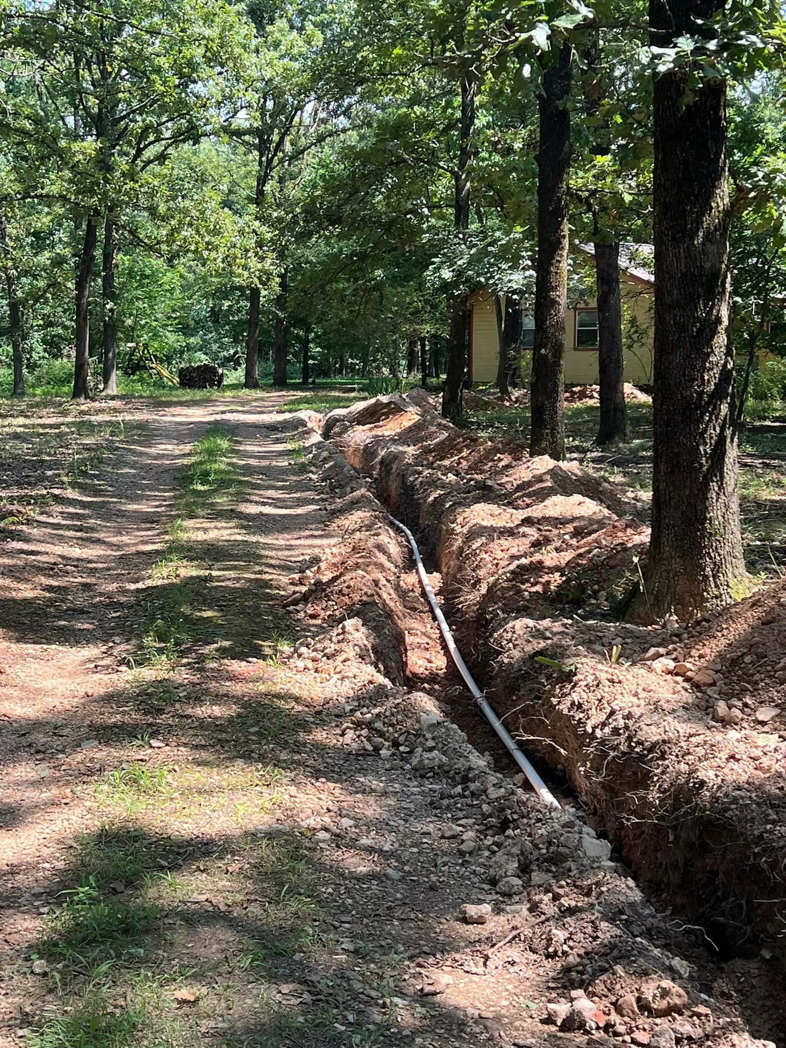 a pipe is being installed in the dirt in the middle of a forest
