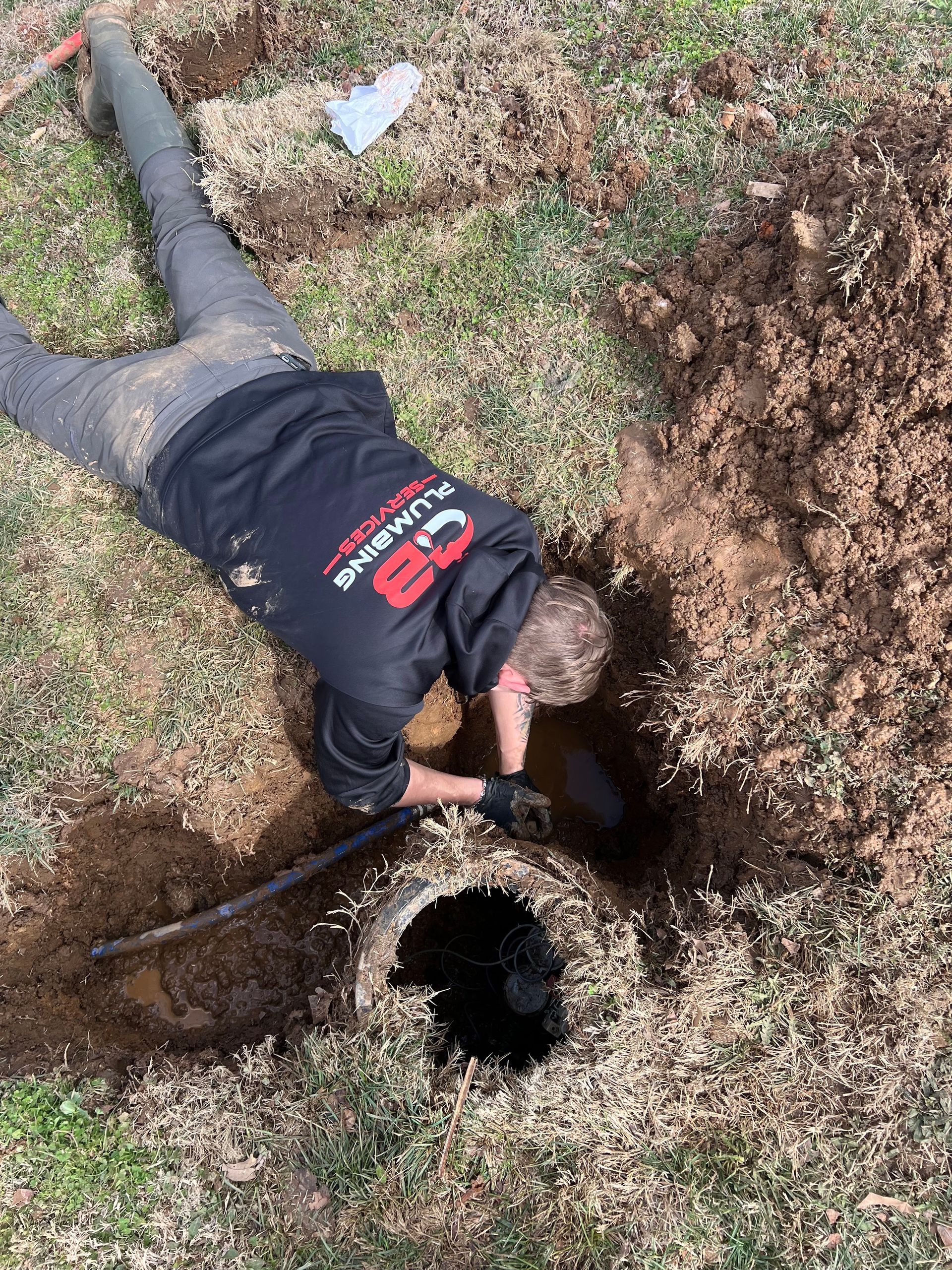 a plumber working and installing pipe on the ground