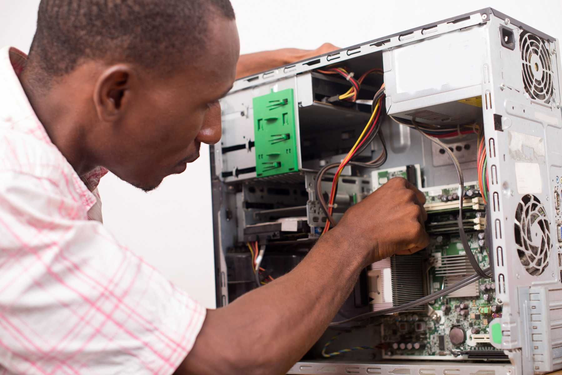 Technician repairing the inside of a desktop computer with the case open
