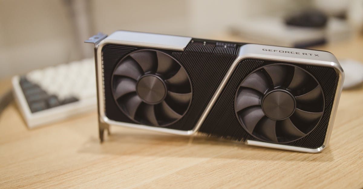 A computer graphics card with two fans is sitting on a wooden table.