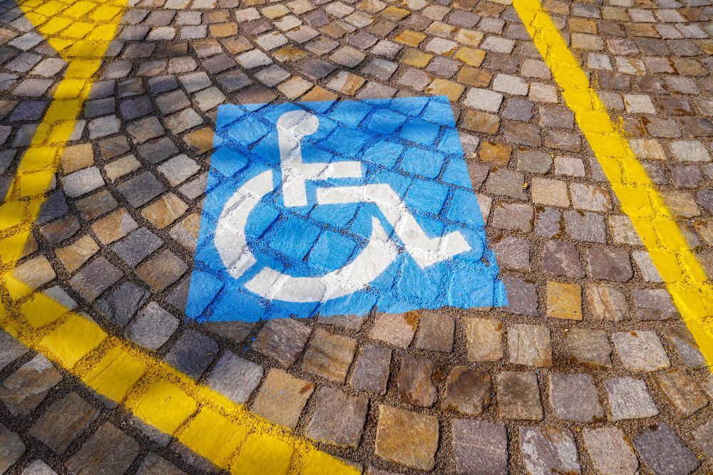 Símbolo azul de acessibilidade para cadeirantes pintado em uma vaga de estacionamento