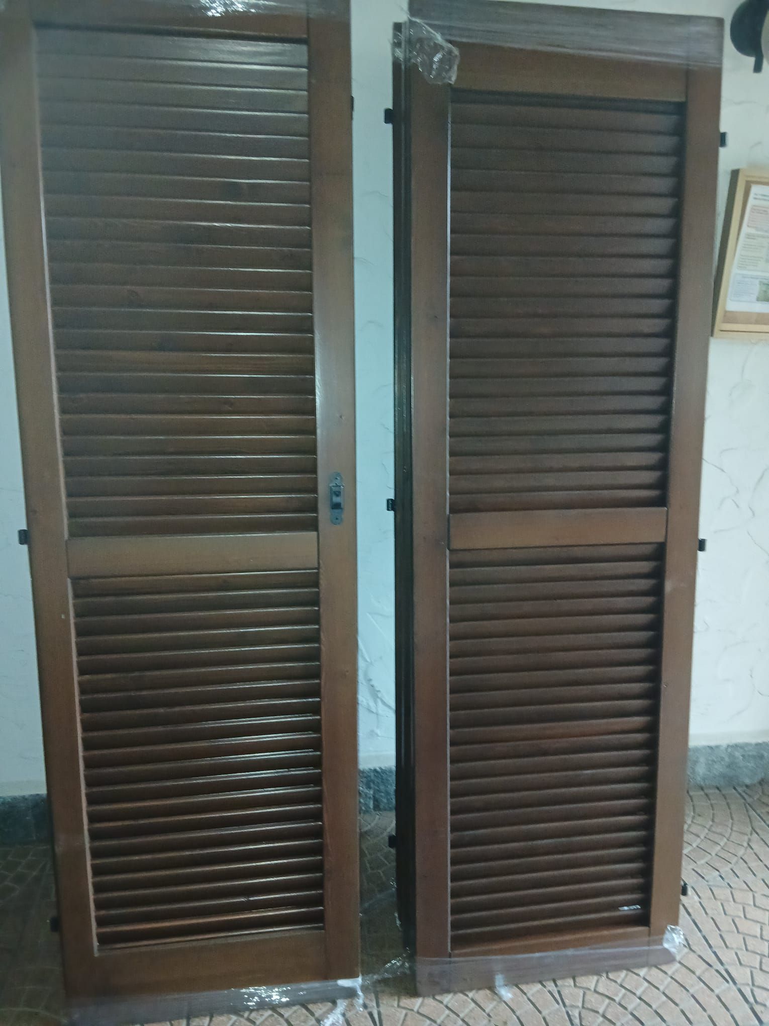 Due porte in legno marrone con listelli, probabilmente destinate a un armadio o a un ripostiglio.