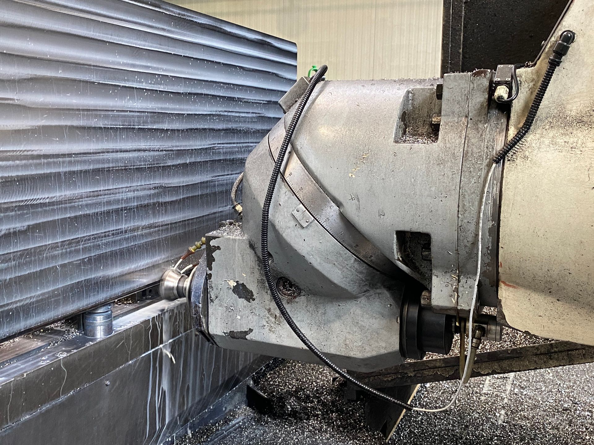 Condotti industriali che spruzzano acqua contro una parete metallica all'esterno.