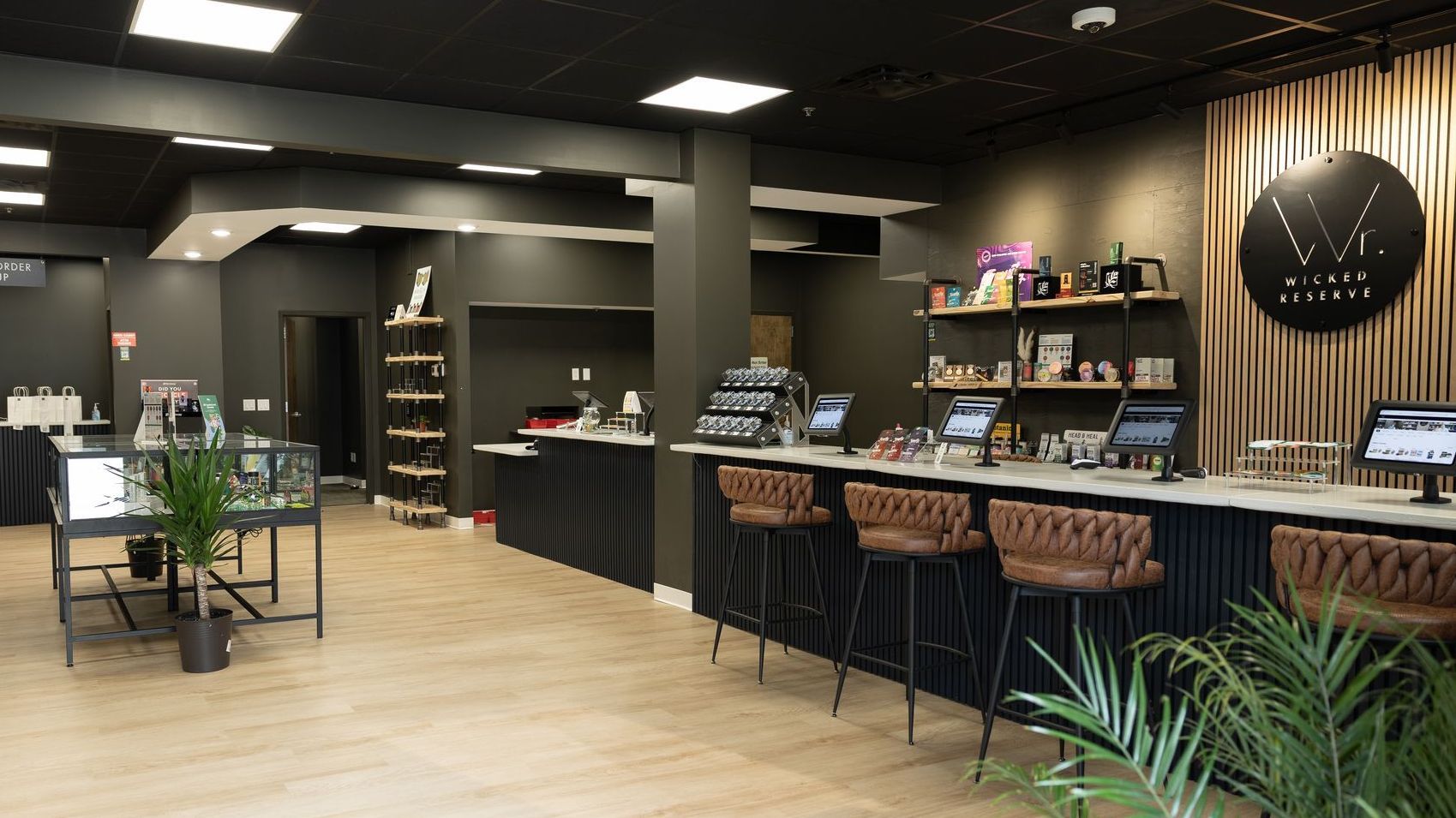 Wicked Reserve’s Rochester showroom with a seated ordering bar, brown stools, product displays, and wood floors.