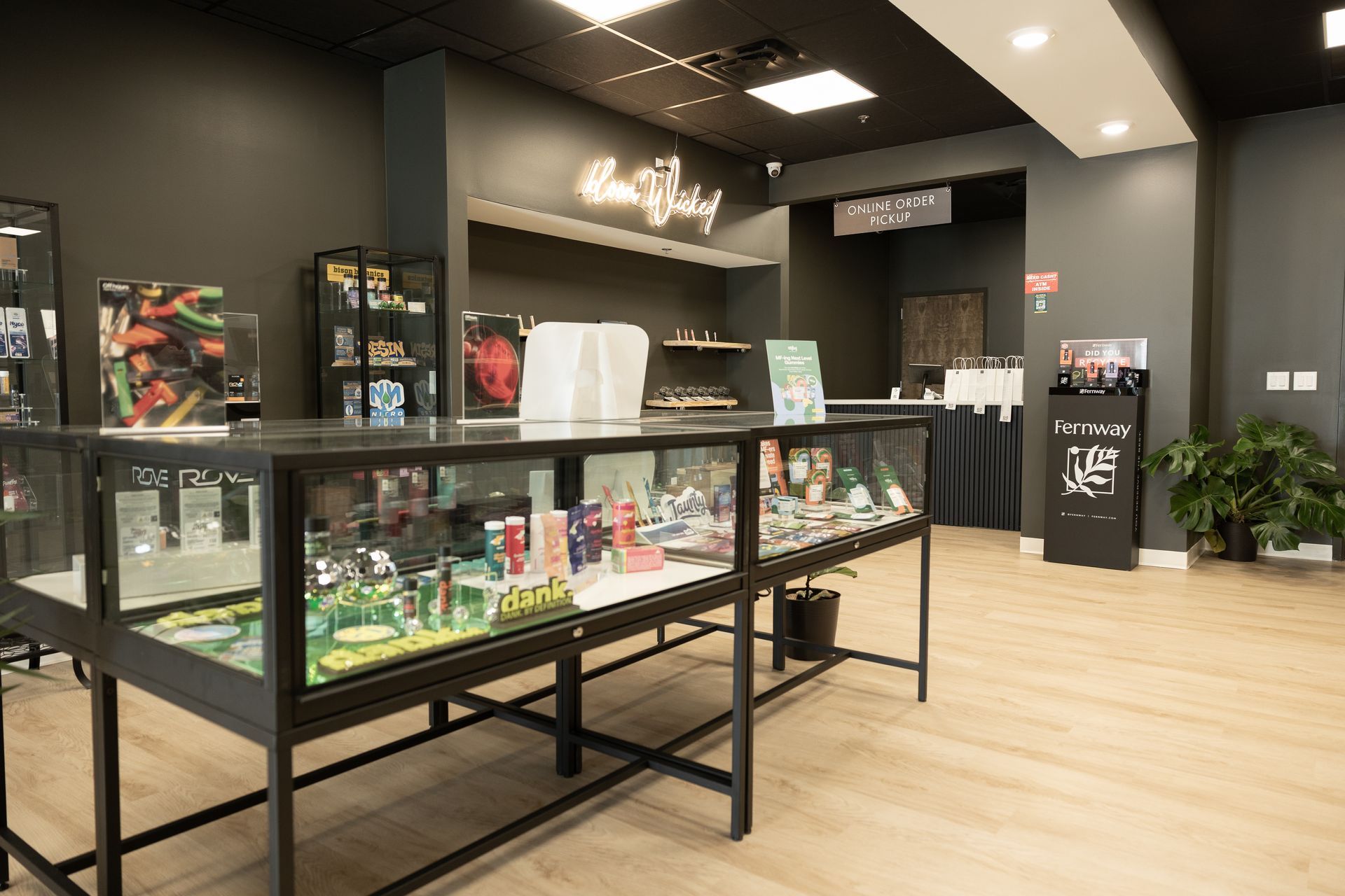 Glass product displays, an online order pickup counter, and plants inside Wicked Reserve in Rochester, NY.