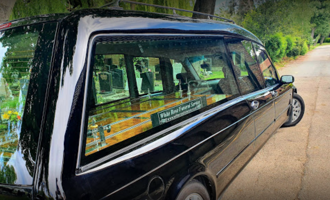 A black hearse is parked on the side of the road.