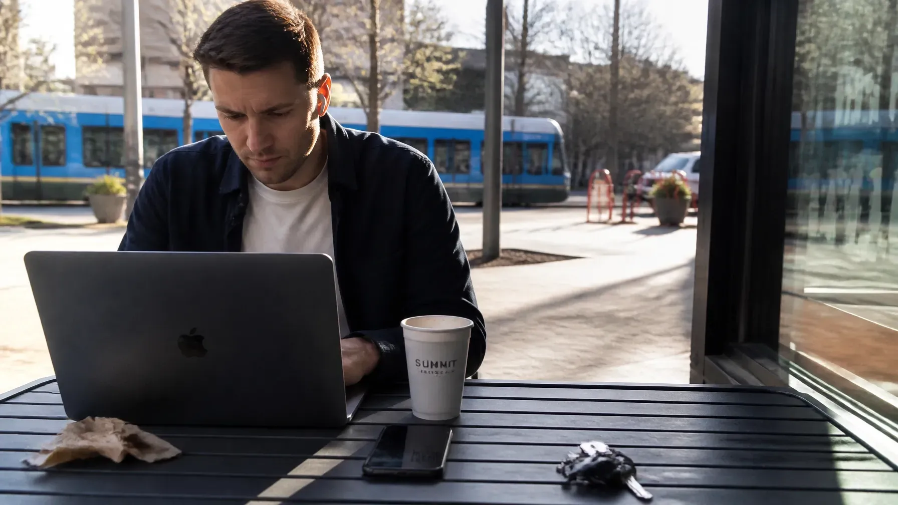 A professional enjoying a local Charlotte lifestyle with a Summit Coffee near the light rail, repres