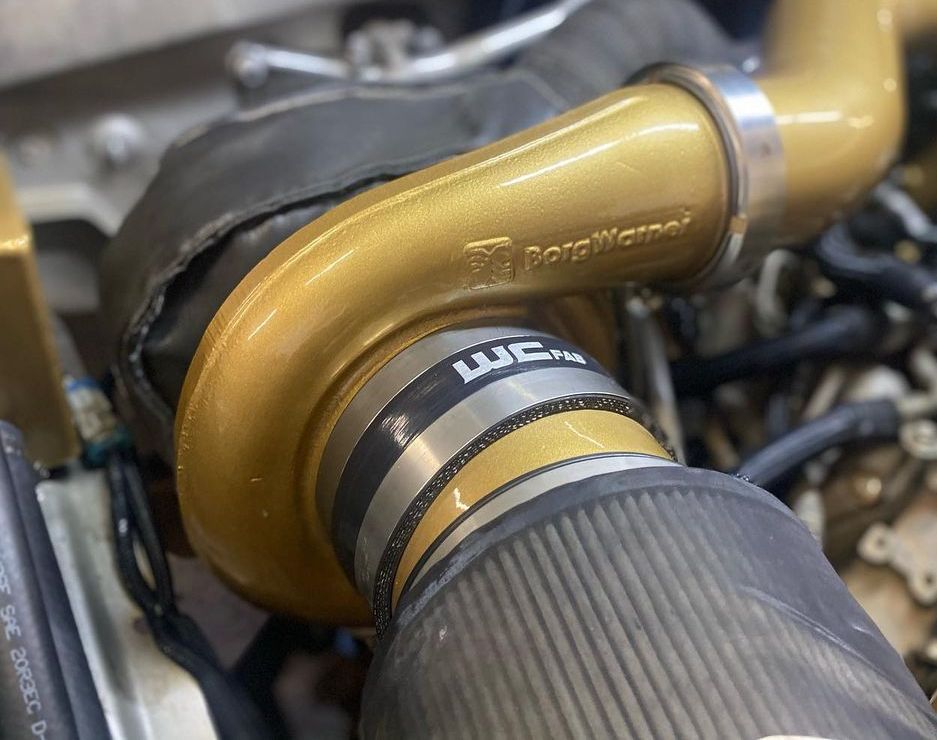 A close up of a turbocharger on a car engine.