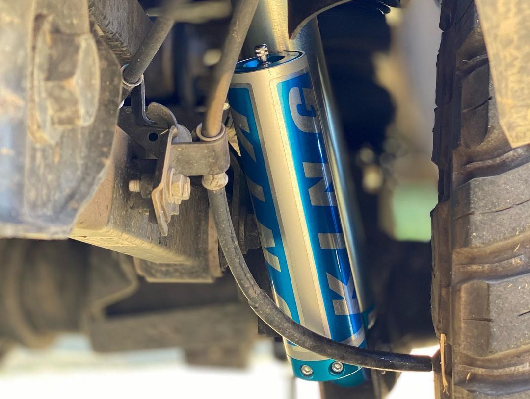 A close up of a shock absorber on a truck.