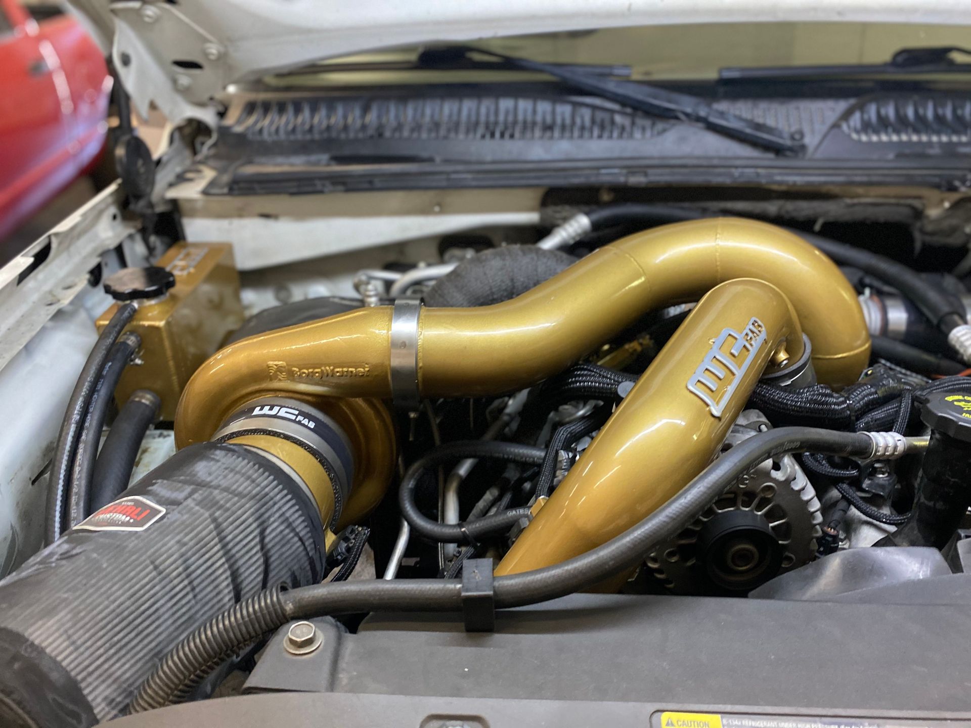 A close up of the engine of a car with the hood open