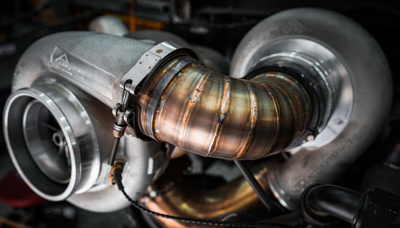 A close up of a turbocharger on a car engine.